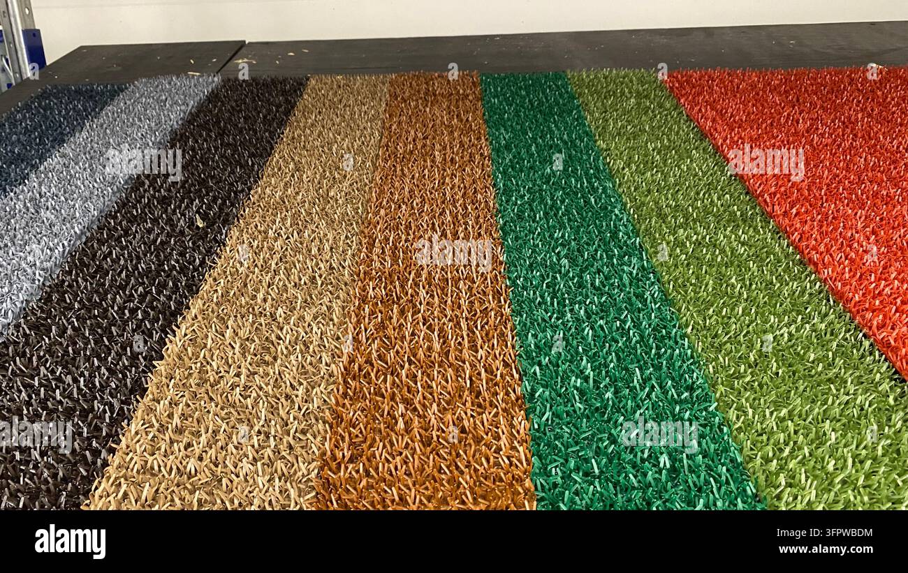 Campioni di erba artificiale colorata e di tappeti erbosi sintetici in diverse sfumature esposti in un negozio di bricolage Foto Stock