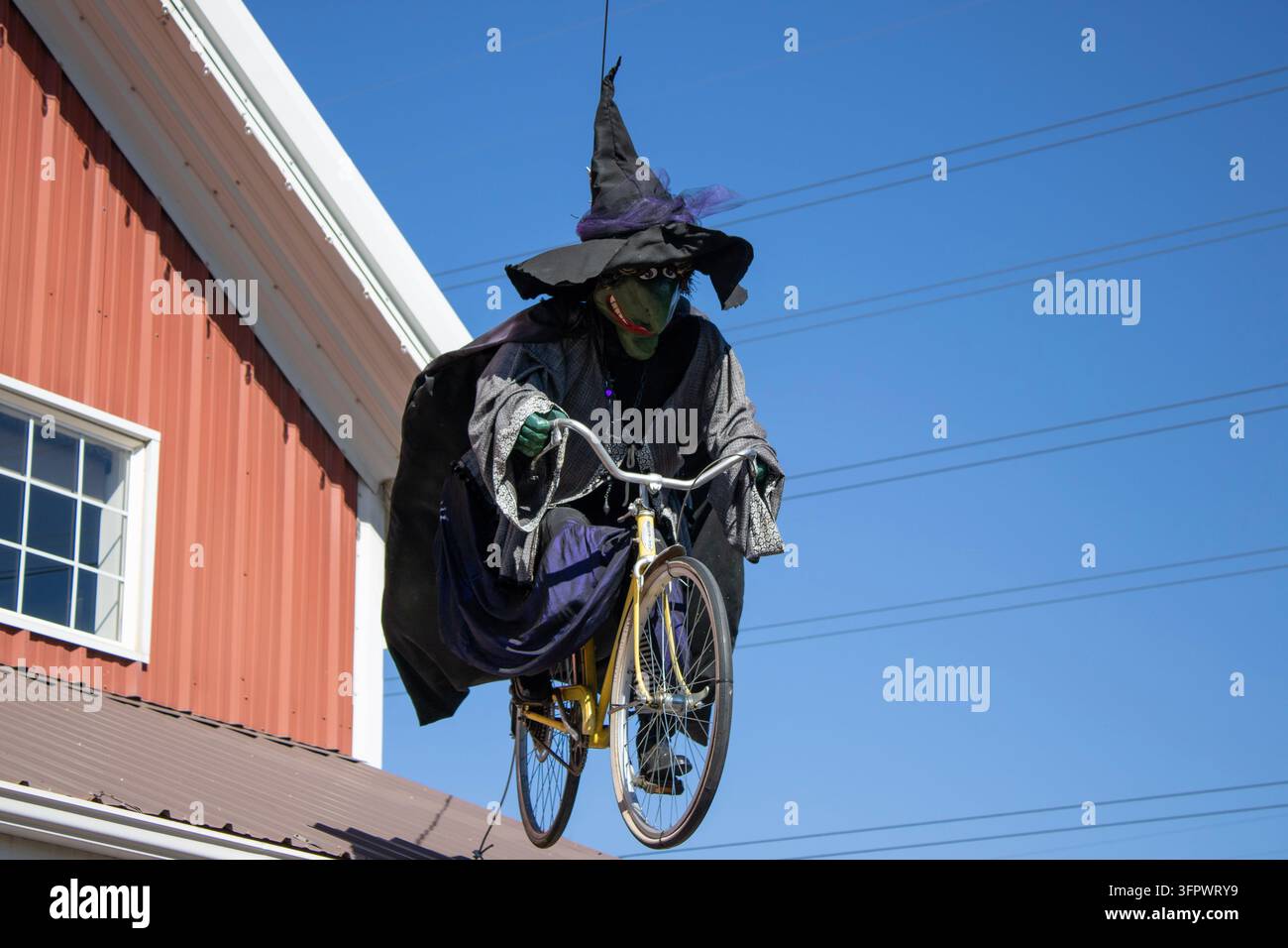 Decorazione di una strega in bicicletta sopra i visitatori Foto Stock