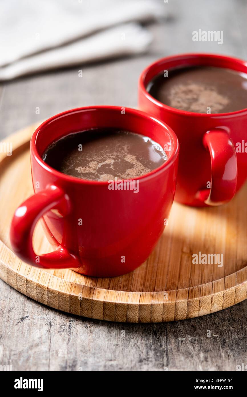 Cioccolata calda in tazza di ceramica rossa su tavolo di legno Foto Stock