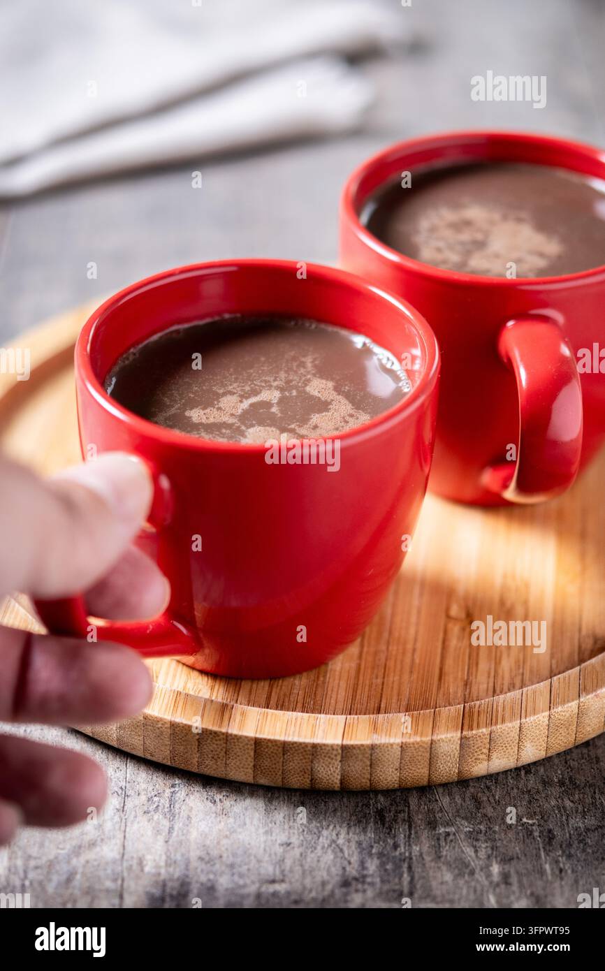 Cioccolata calda in tazza di ceramica rossa su tavolo di legno Foto Stock