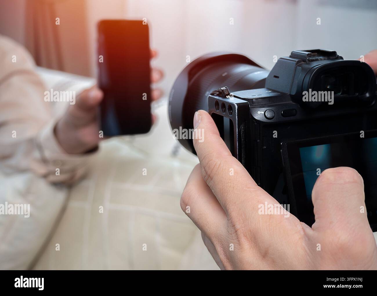 Veduta posteriore della mano di un fotografo creativo professionista che scatta una foto per una pubblicità. Fotografo che scatta una foto nello studio di ripresa. Foto Stock