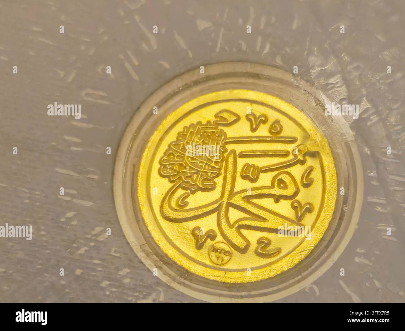 Il Cairo, Egitto, 26 settembre 2026: una moneta d'oro islamica con calligrafia araba del nome del Profeta Maometto, pace sia su di lui, coniata da BTC Egy Foto Stock