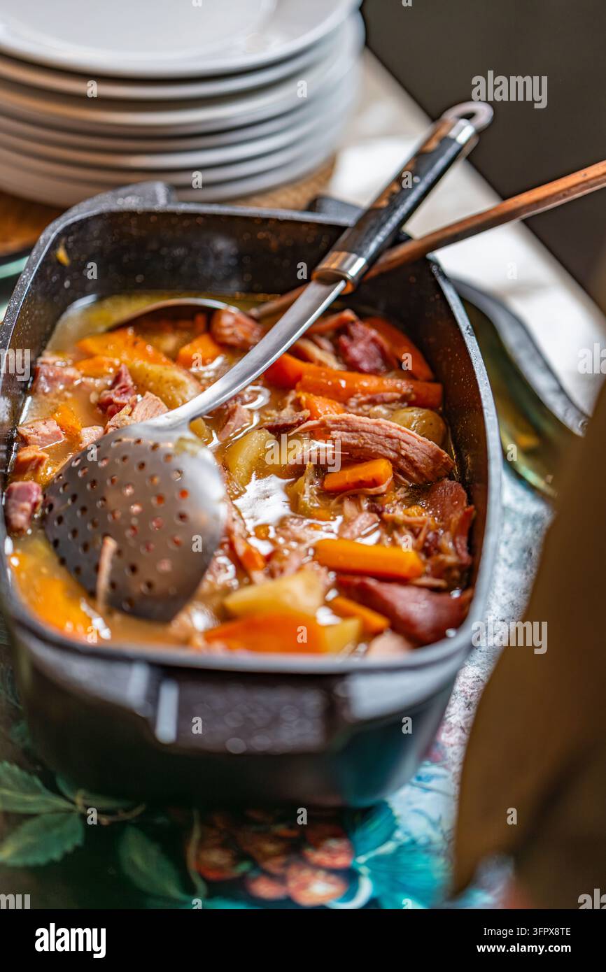 Stufato di arrosto di prosciutto con carote e patate in una casseruola di ghisa servito per un pranzo di riprese in una tenuta di campagna scozzese Foto Stock