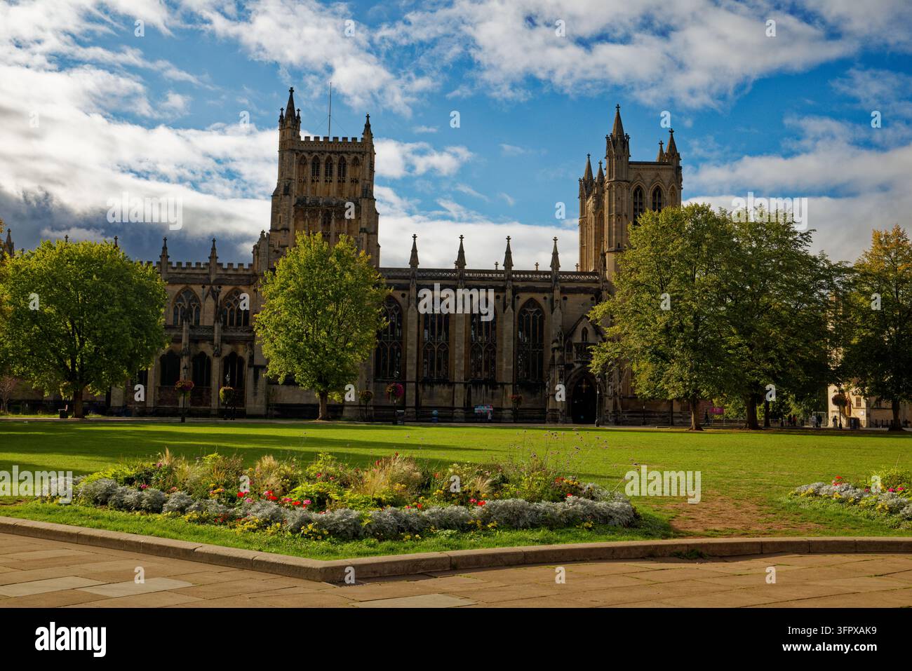 Aiuoli, erba del prato e alberi in una piazza pubblica davanti alla facciata nord della Cattedrale di Bristol, Bristol, Inghilterra. Foto Stock
