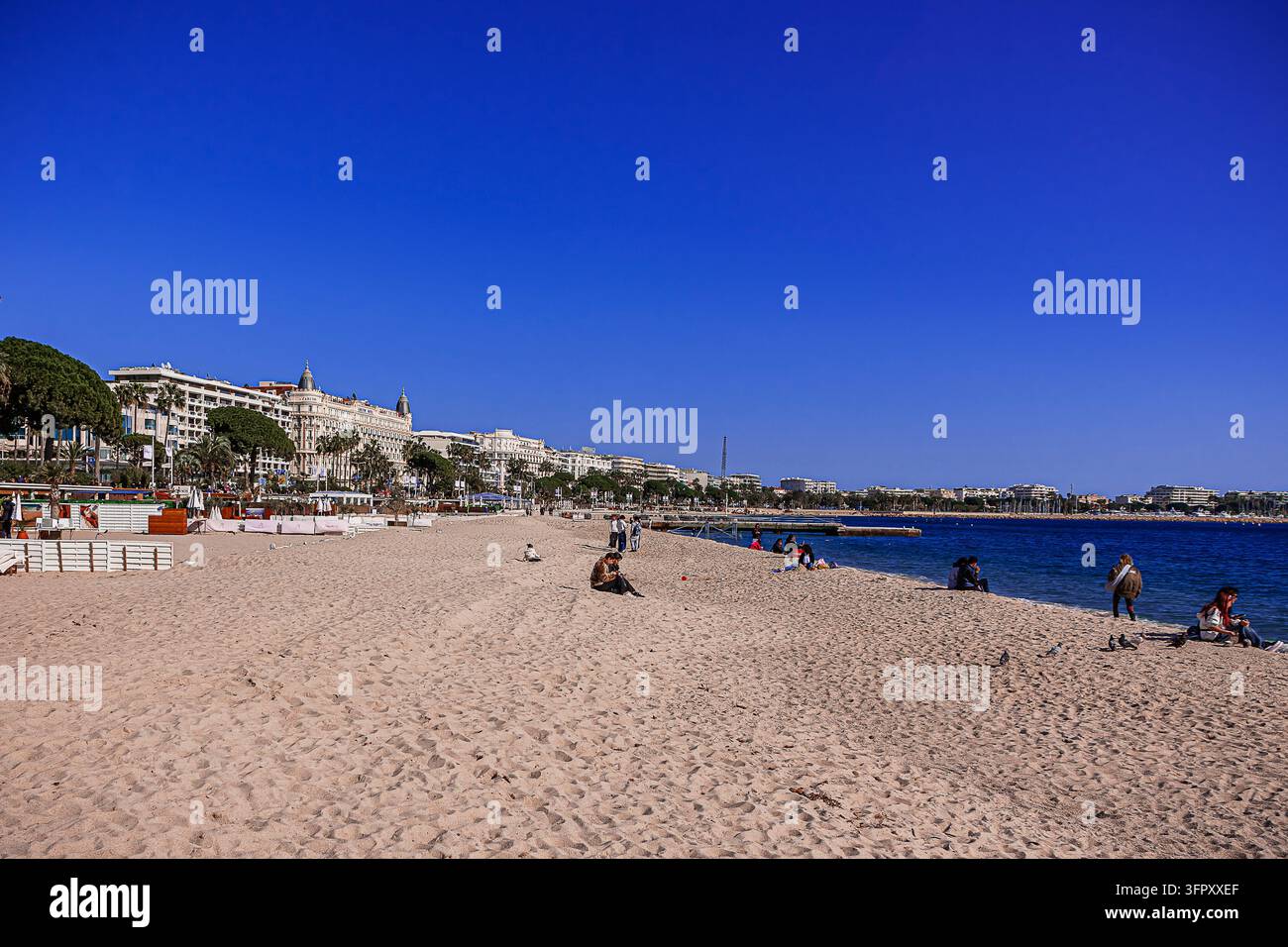 Persone che si rilassano e godono del caldo sole primaverile sulla bellissima spiaggia sabbiosa di Cannes Foto Stock