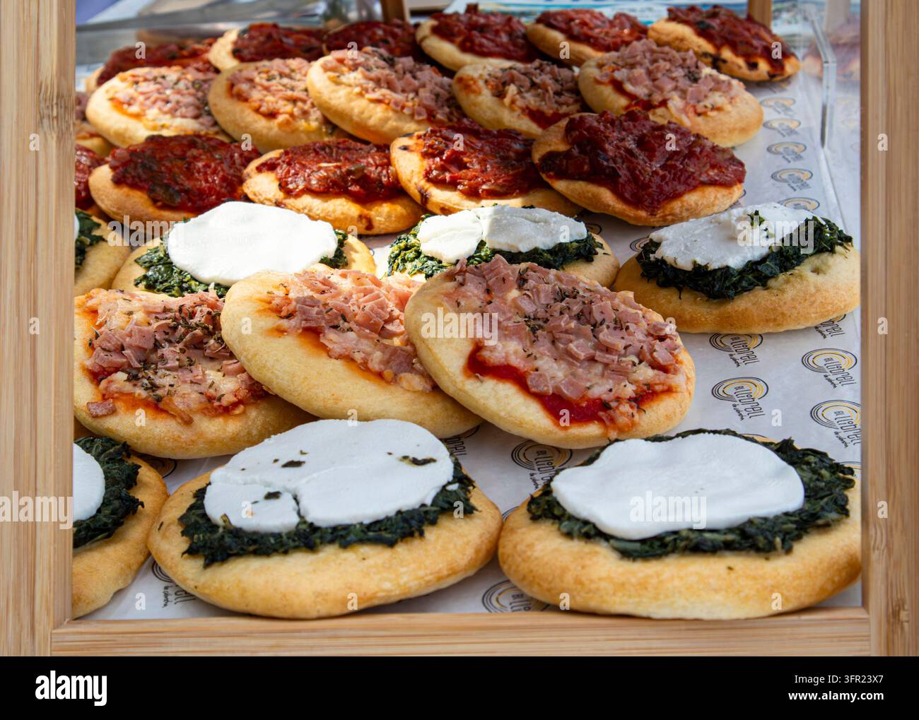 Mini pizze e cocas spagnole tradizionali con vari condimenti salati Foto Stock