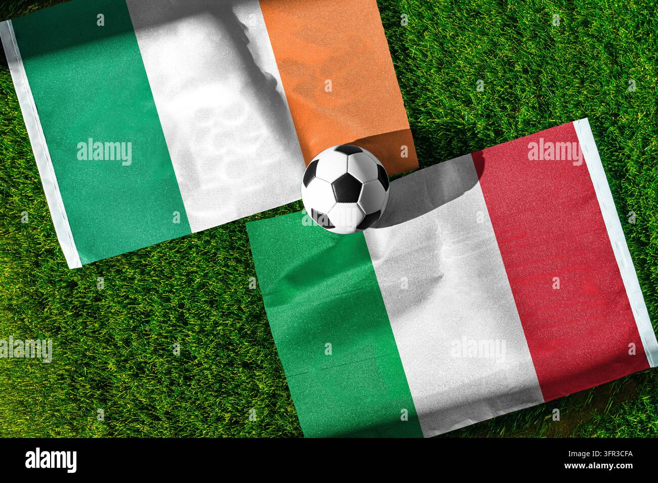 Partita di calcio Repubblica d'Irlanda contro Italia. Bandiere nazionali sull'erba verde con un pallone da calcio al centro. Sfondo di calcio per partita internazionale Foto Stock