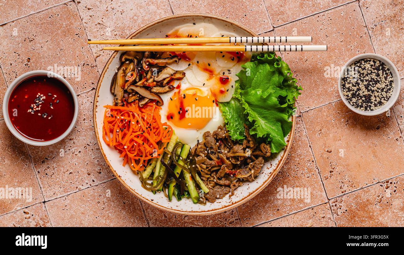 Bibimbap con verdure colorate, manzo e uovo in una ciotola Foto Stock