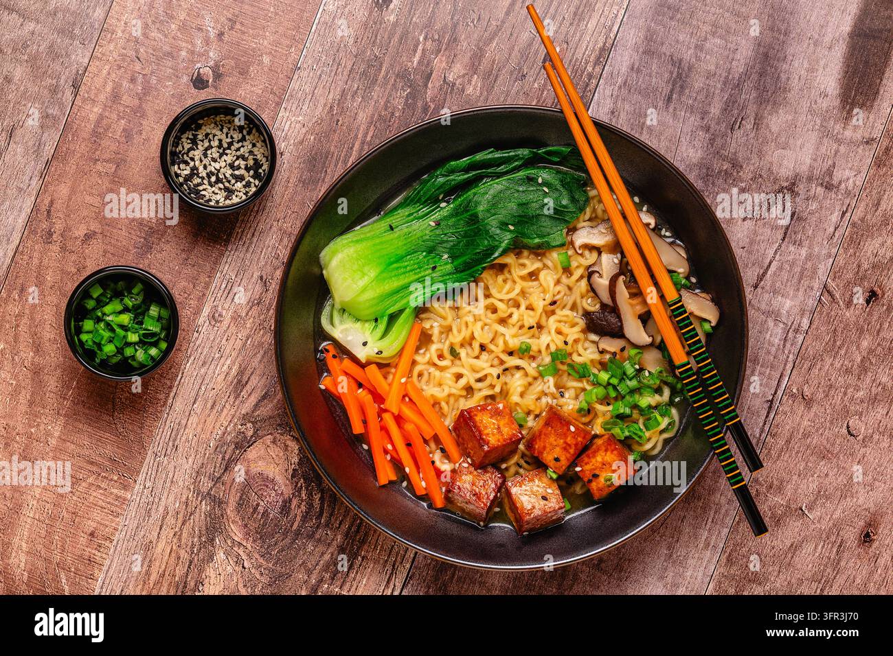 Zuppa miso ramen con noodles servita con tofu, bok choy, carote e funghi in una ciotola. Foto Stock