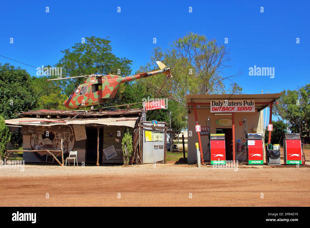 Daly Waters Pub Outback Servo con un elicottero esposto sul tetto accanto alle pompe di carburante a Daly Waters, Territorio del Nord, Australia. Foto Stock