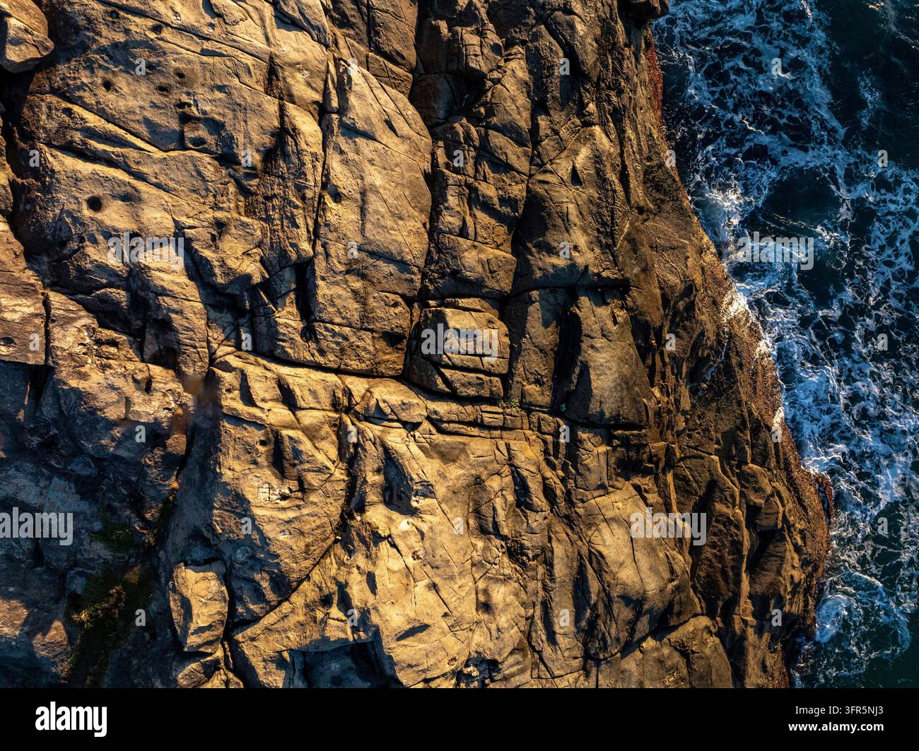 Florianopolis Vista nadir su rocce e onde oceaniche che si infrangono alla spiaggia di Armacao a Santa Catarina, Brasile, veduta aerea Foto Stock