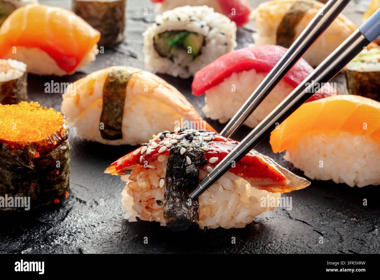 Sushi con bacchette. Sushi Unagi, Nigiri con anguilla e altre varianti e roll di sushi Foto Stock
