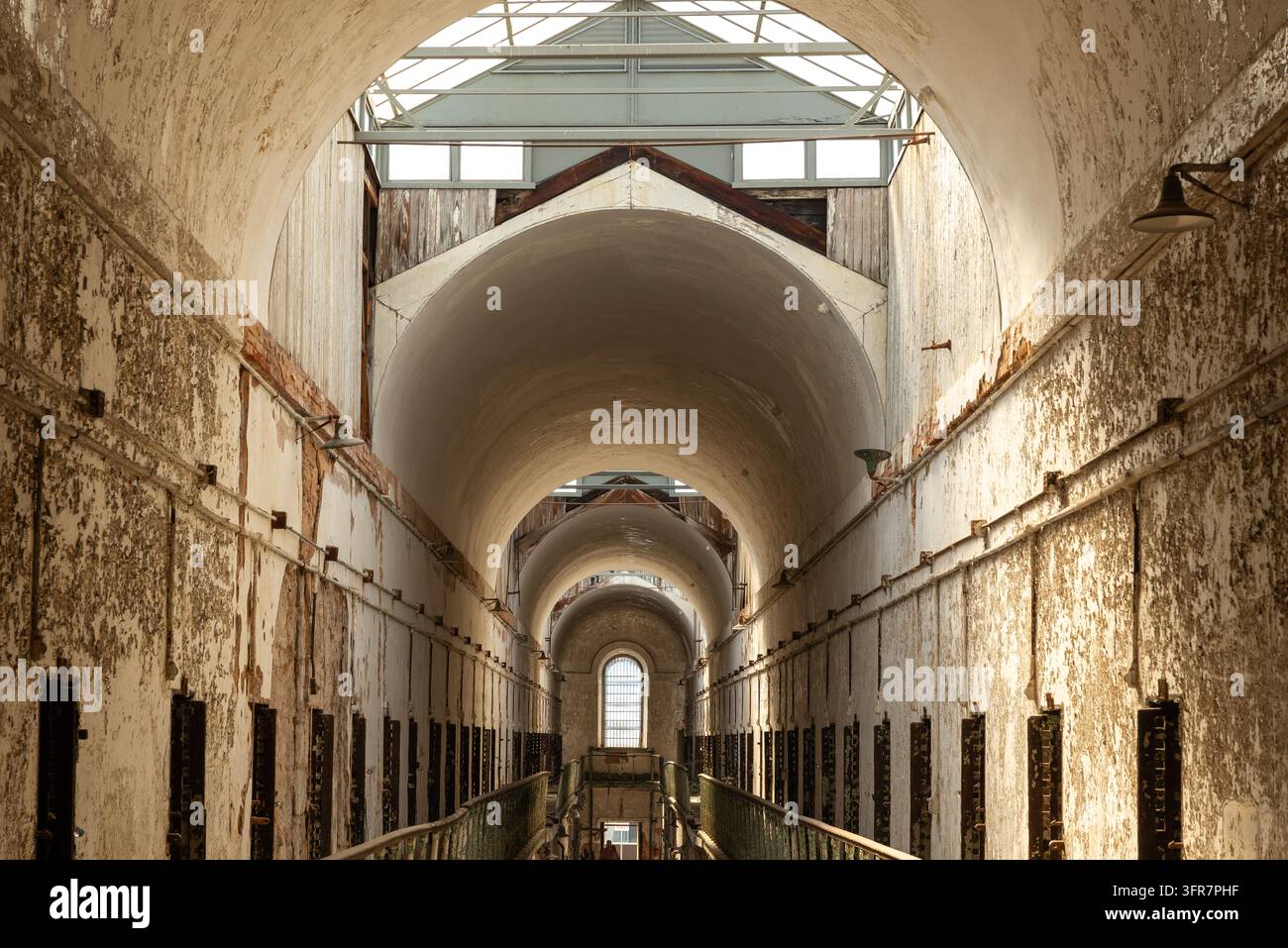 Vista interna dei corridoi storici dei blocchi cellulari dell’Eastern State Penitentiary a Filadelfia, Pennsylvania. L’ex prigione è nota per la sua dis… Foto Stock