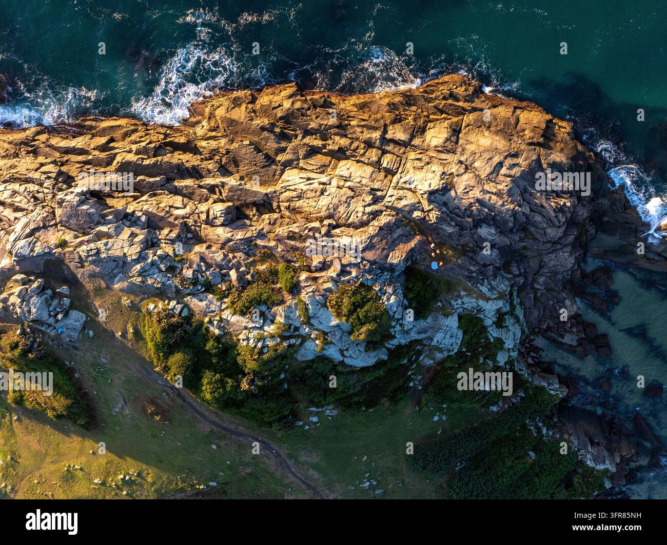 Florianopolis Vista nadir su rocce e onde oceaniche che si infrangono alla spiaggia di Armacao a Santa Catarina, Brasile, veduta aerea Foto Stock