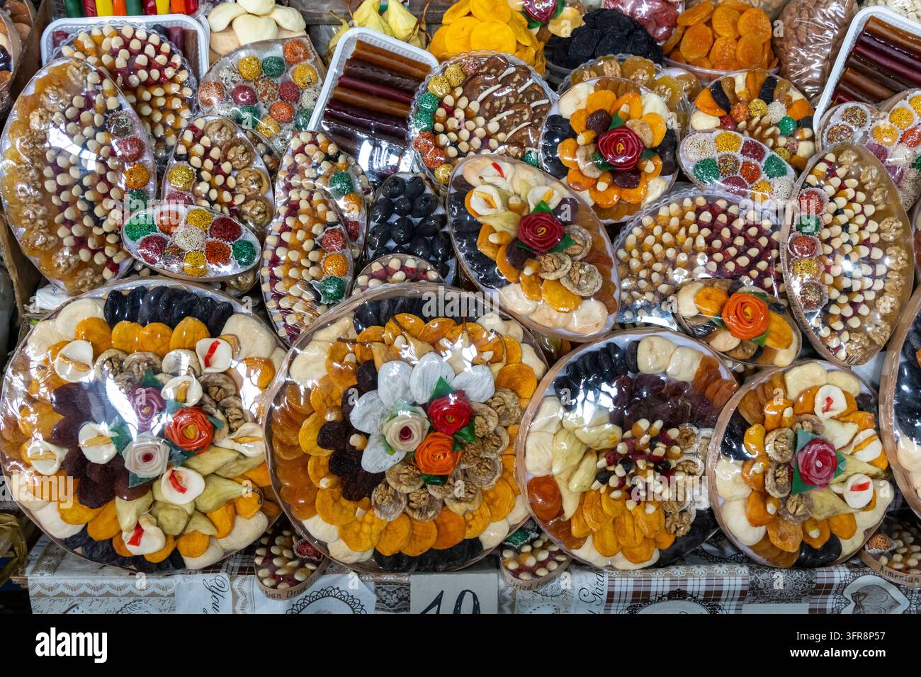 Piatto decorativo di frutta secca e noci armene essiccate disposte con fiori di zucchero in vendita su un banco del mercato, Yerevan, Yerevan, Armenia Foto Stock