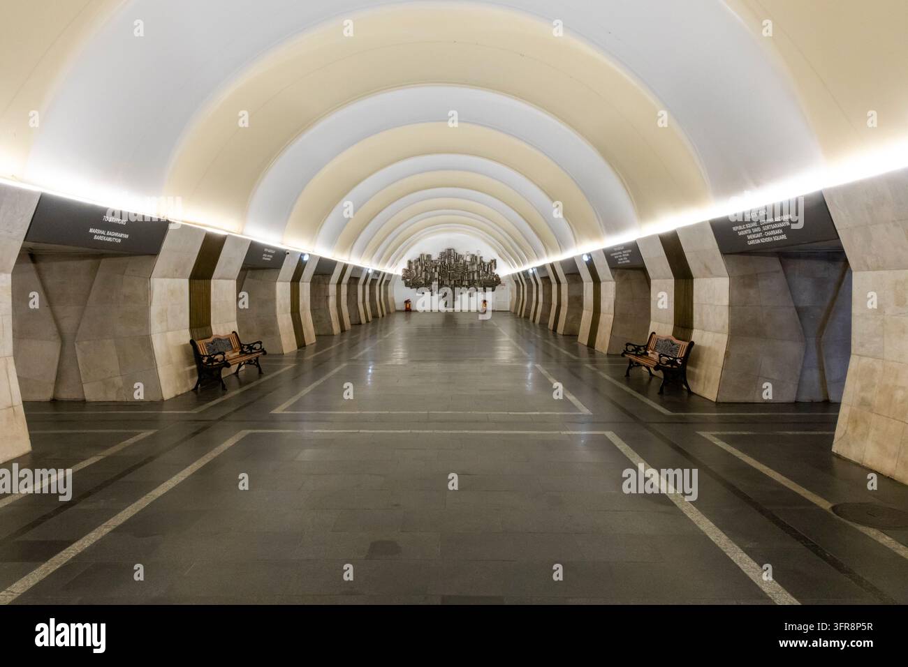 Sala vuota della stazione della metropolitana Yeritasardakan con soffitto ad arco, panchine e una scultura in metallo all'estremità, Yerevan, Yerevan, Armenia Foto Stock