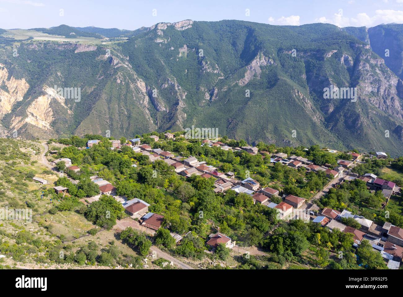 Veduta aerea di un villaggio di montagna circondato da scogliere boschive, provincia di Syunik, Tatev, Armenia Foto Stock