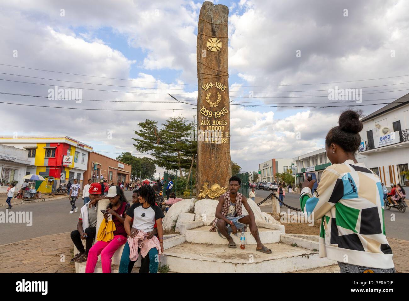 Persone che si radunano attorno a un monumento ai caduti che onora i soldati malgaci nel centro della città di Haute Matsiatra, Fianarantsoa, Madagascar Foto Stock