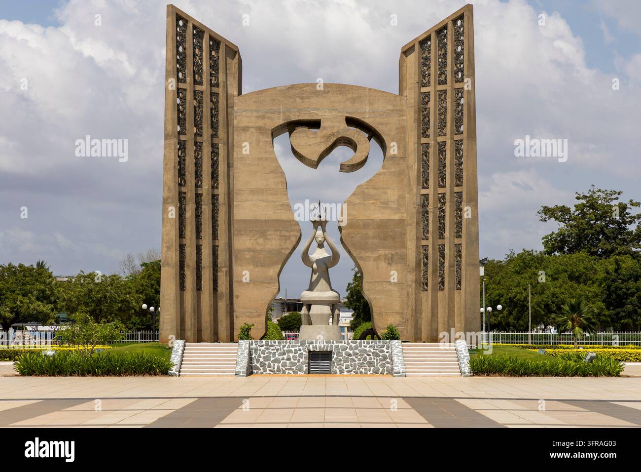 Grande monumento di indipendenza in cemento con una statua che tiene una torcia tra i suoi due pilastri, Regione Marittima, Lomé, Togo Foto Stock