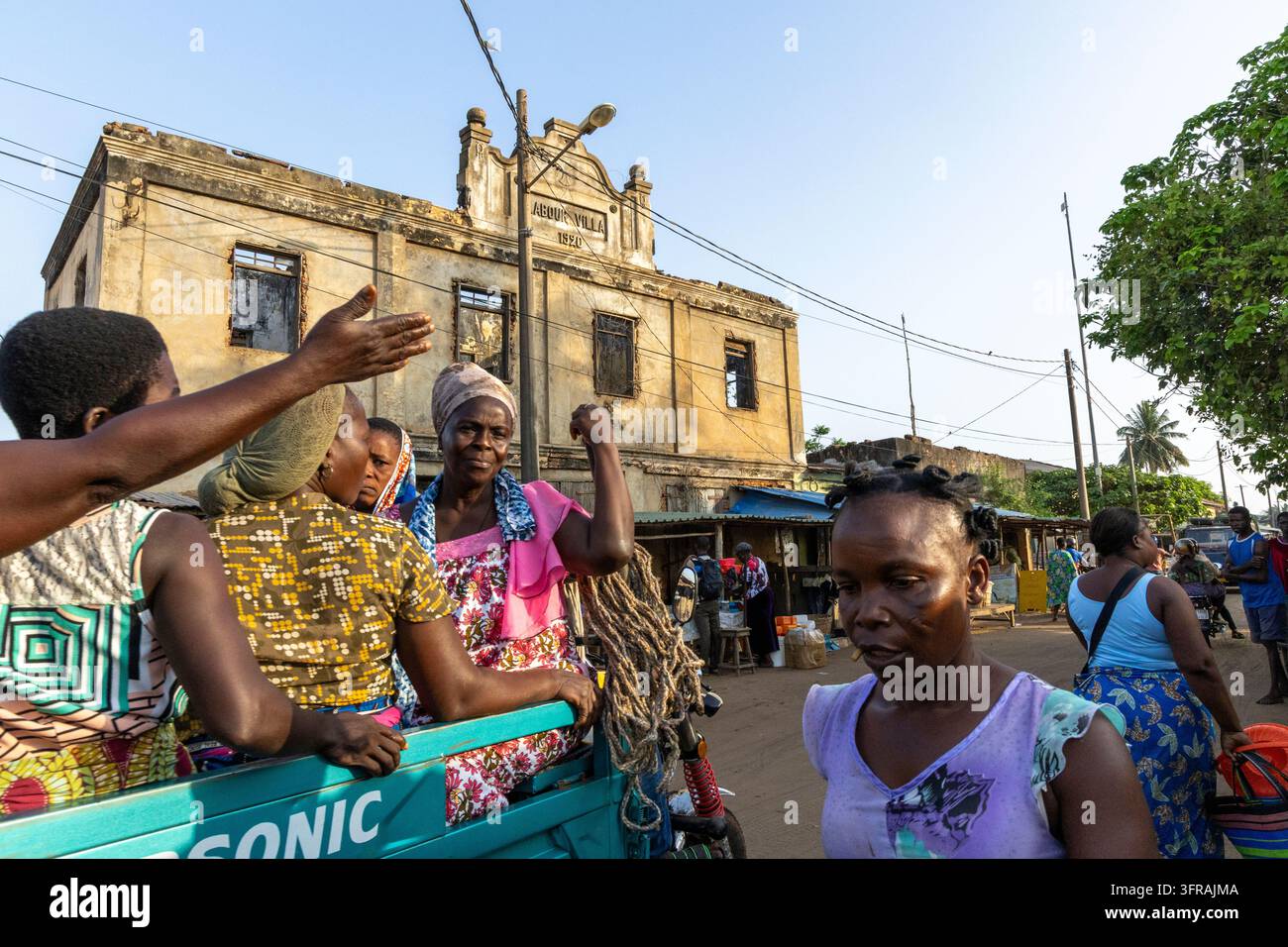 Donne radunate vicino a un antico edificio coloniale in un mercato di strada, regione marittima, Aneho, Togo Foto Stock