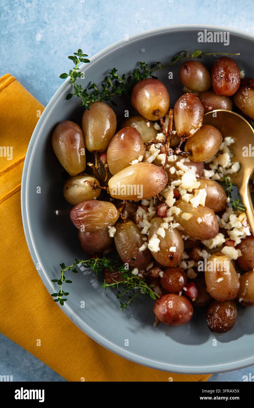 Uva rossa arrosto con bordi caramellati e una texture leggermente rugosa, servita calda come semplice contorno dolce e salato o antipasto Foto Stock