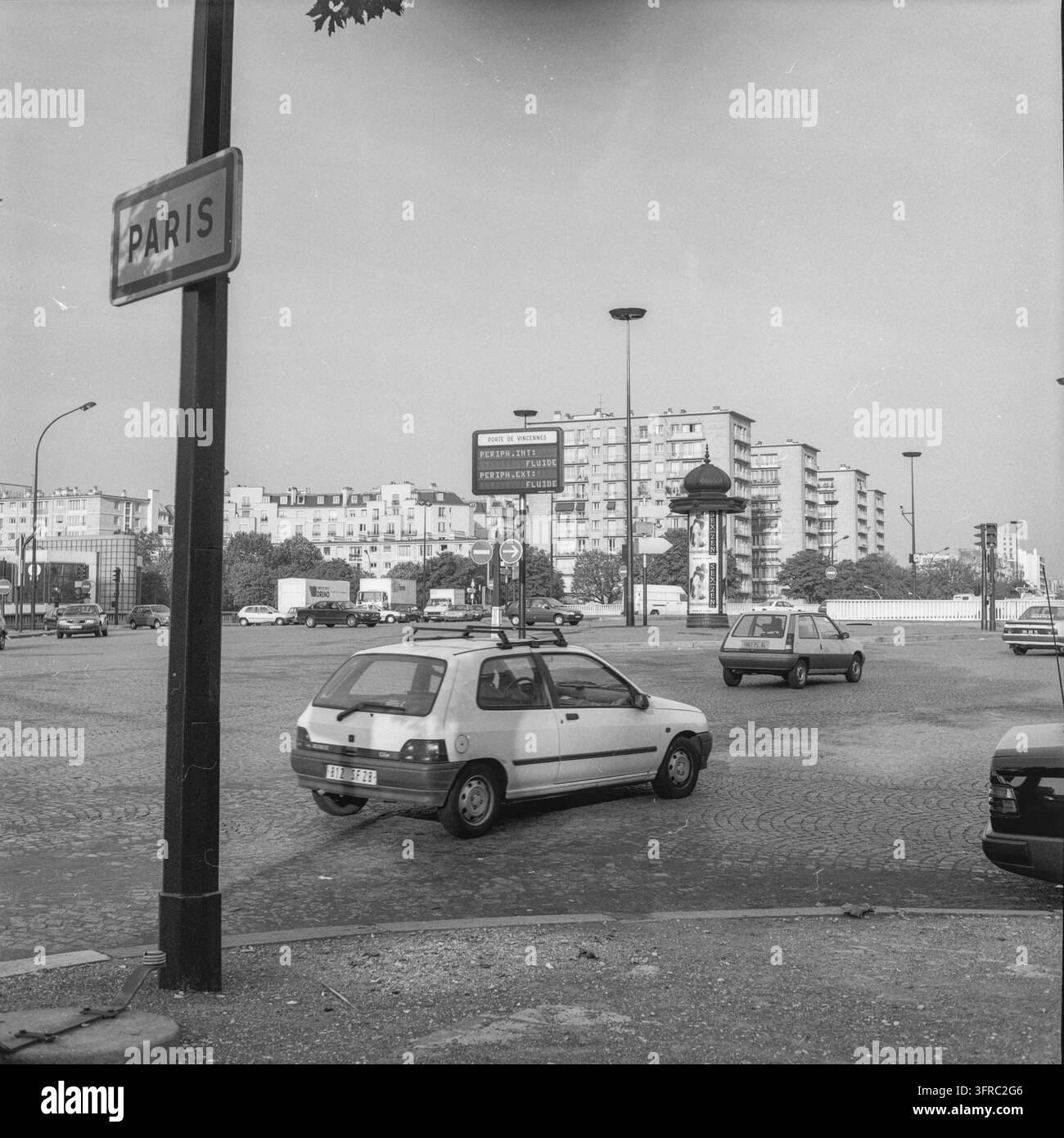 Auto che attraversano un incrocio stradale parigino sotto un cartello stradale di Parigi, 1996. Foto Stock