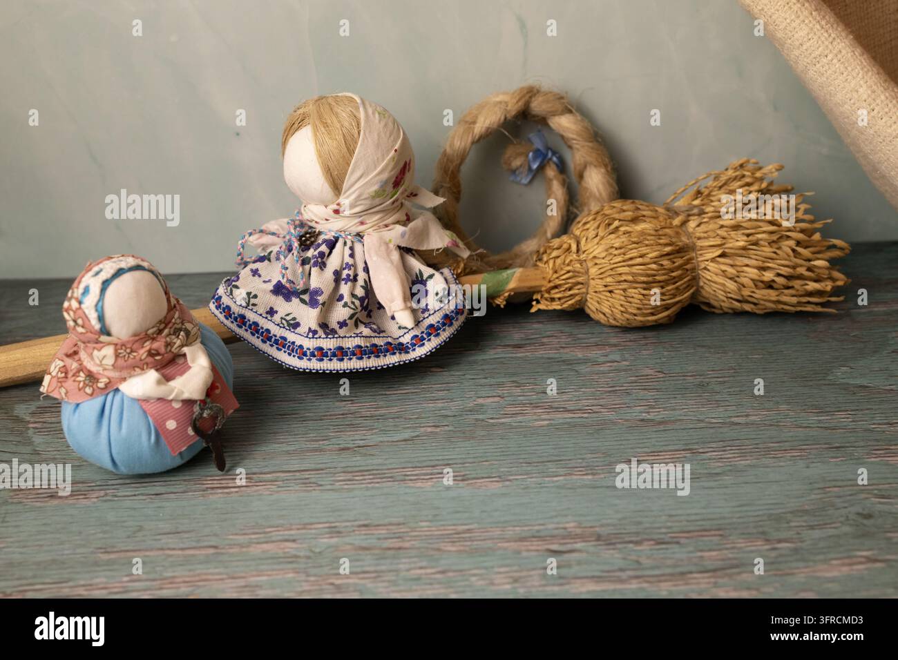 Bambole popolari tradizionali fatte a mano e mazzo di grano su tavolo di legno rustico Foto Stock