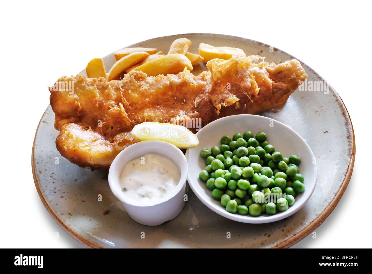 Pesce fritto tradizionale britannico e patatine fritte serviti su un piatto con piselli, salsa tartara e una fetta di limone, isolati su sfondo bianco. Foto Stock