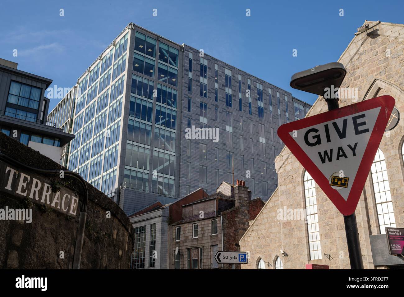 L'architettura moderna in vetro del Silver Fin Office Building si erge sopra gli edifici tradizionali in granito di Aberdeen City sotto un cielo blu intenso Foto Stock