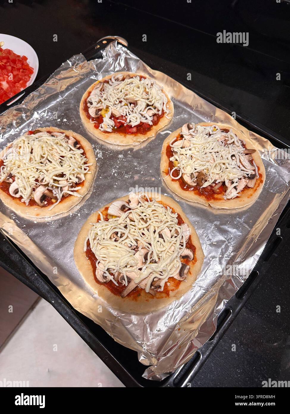 Quattro mini pizze fatte in casa con funghi e formaggio mozzarella . Foto di alta qualità Foto Stock