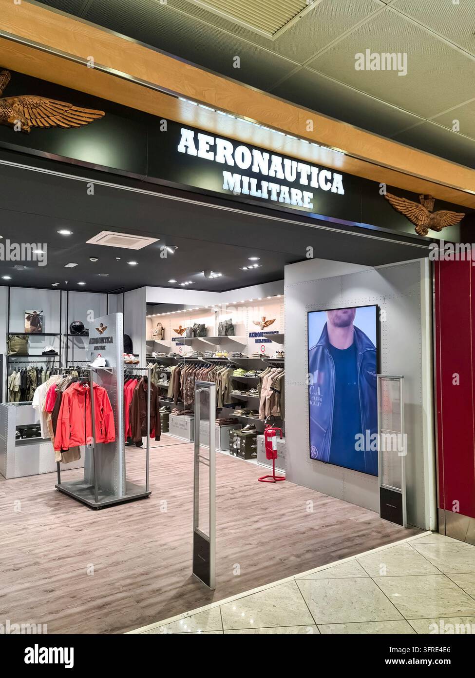 Napoli, Italia - 09 marzo 2026: Ingresso di un negozio di abbigliamento Aeronautica Militare che mostra moda di ispirazione militare all'interno di un aeroporto commerciale Foto Stock