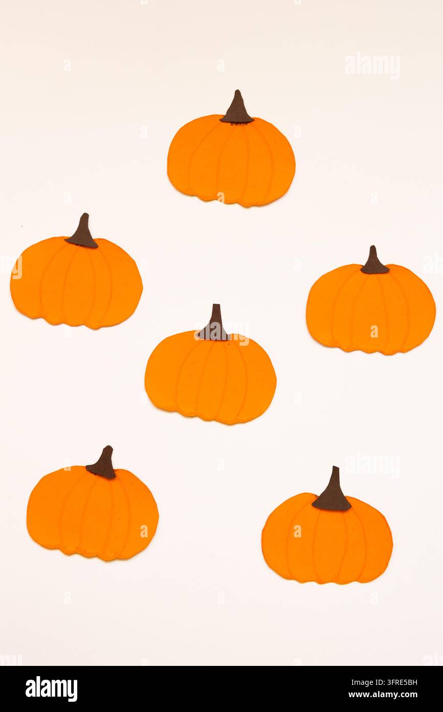 Zucca di carta su sfondo bianco con un design decorativo per progetti grafici, pubblicità e contenuti stagionali Foto Stock