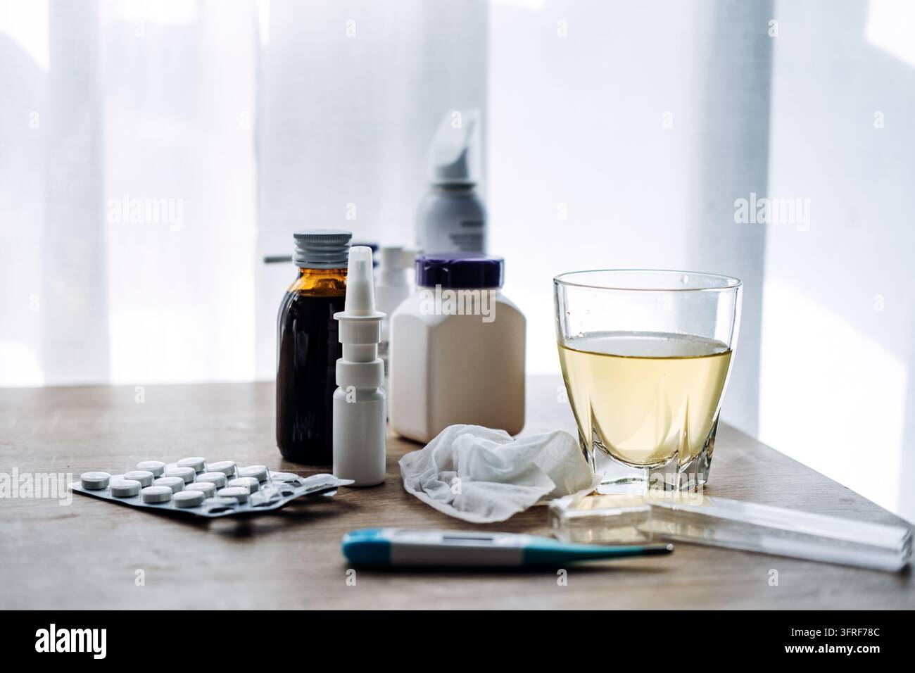 Spray decongestionante tra compresse, sciroppo per la tosse, fazzoletto e termometro, rimedi di tutti i giorni per il naso chiuso durante il freddo Foto Stock
