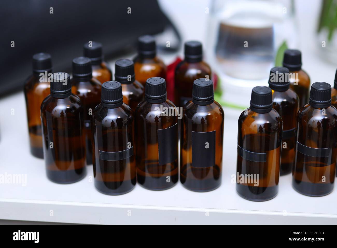 Bottiglie di vetro ambrato con etichette bianche, ideali per cosmetici naturali, oli essenziali, aromaterapia e branding di prodotti benessere. Foto Stock