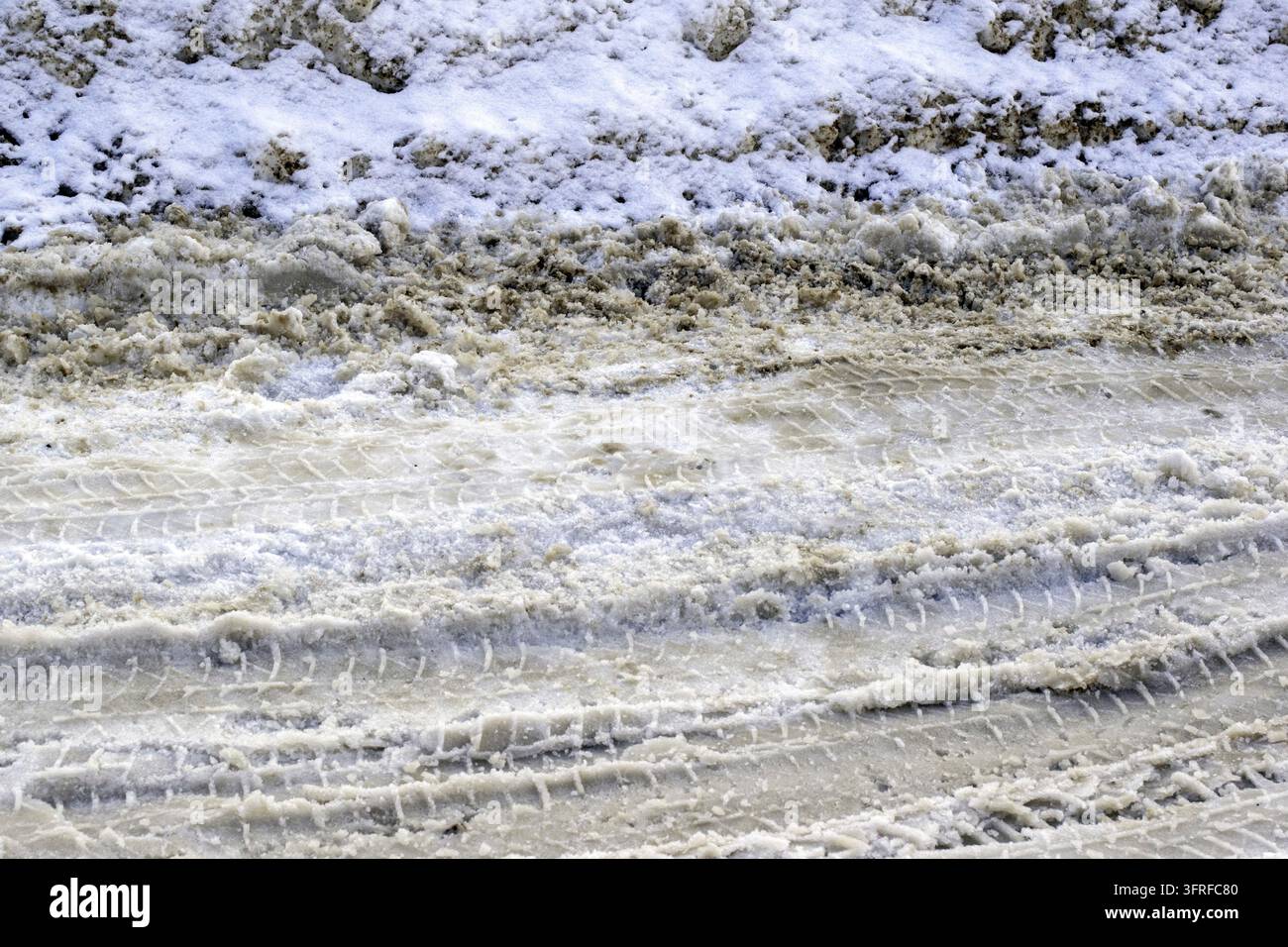 Tracce di pneumatici su strada innevata.Strada coperta di neve, guida invernale Foto Stock