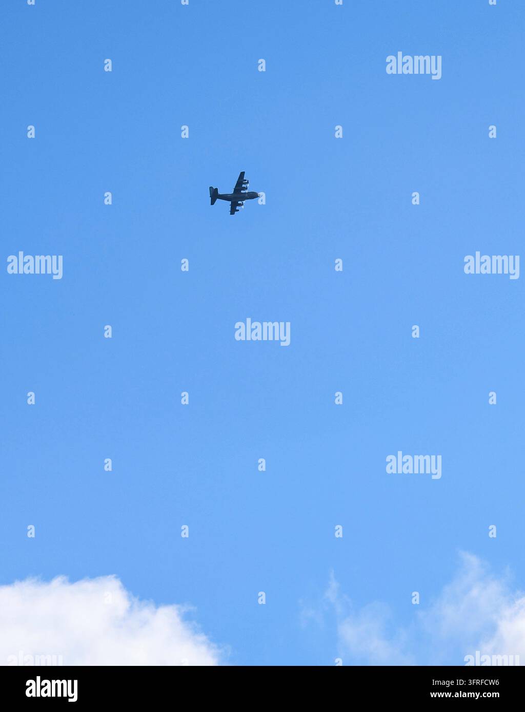 Aereo da trasporto militare pesante che vola su un cielo blu terso in una missione logistica vitale, mostrando potenza e capacità aerea Foto Stock