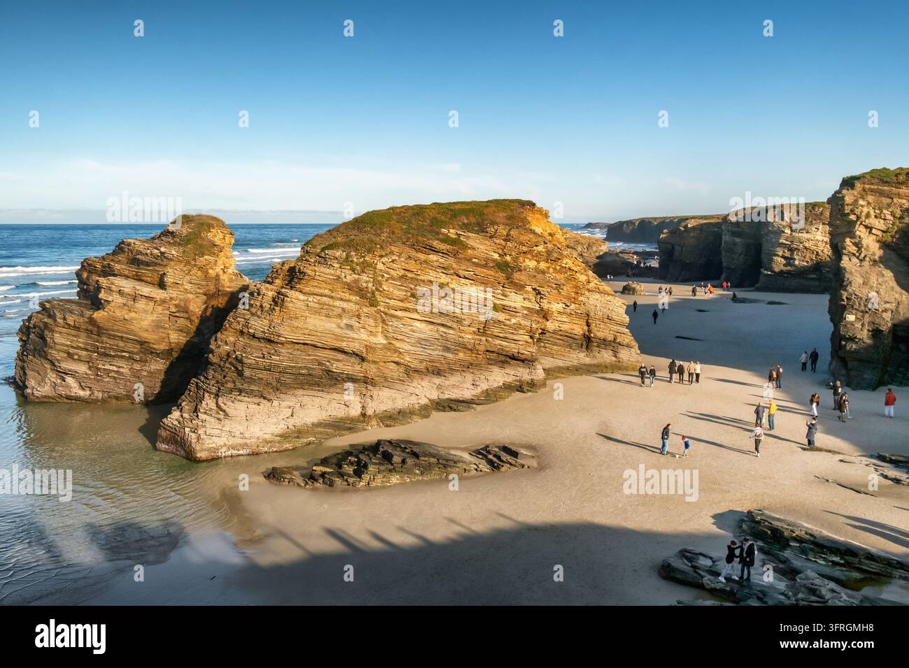 Formazioni rocciose della Playa de las Catedrales e bagnanti alla bassa marea in Galizia Foto Stock