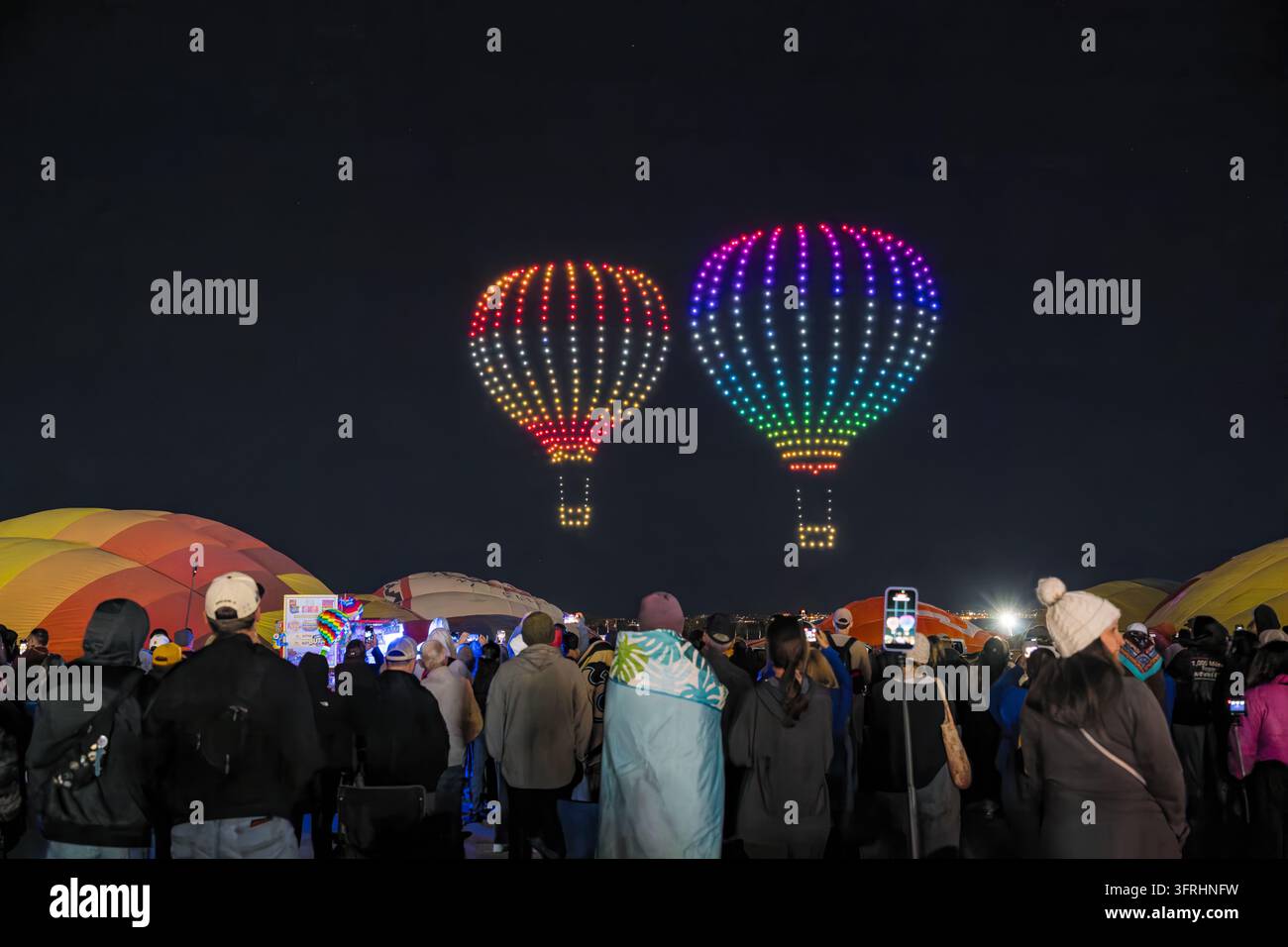 Nuovo Messico, Stati Uniti, 02 OTT 2026 – Una folla di spettatori osserva uno spettacolo di luci con droni che forma due mongolfiere illuminate nel cielo notturno Foto Stock