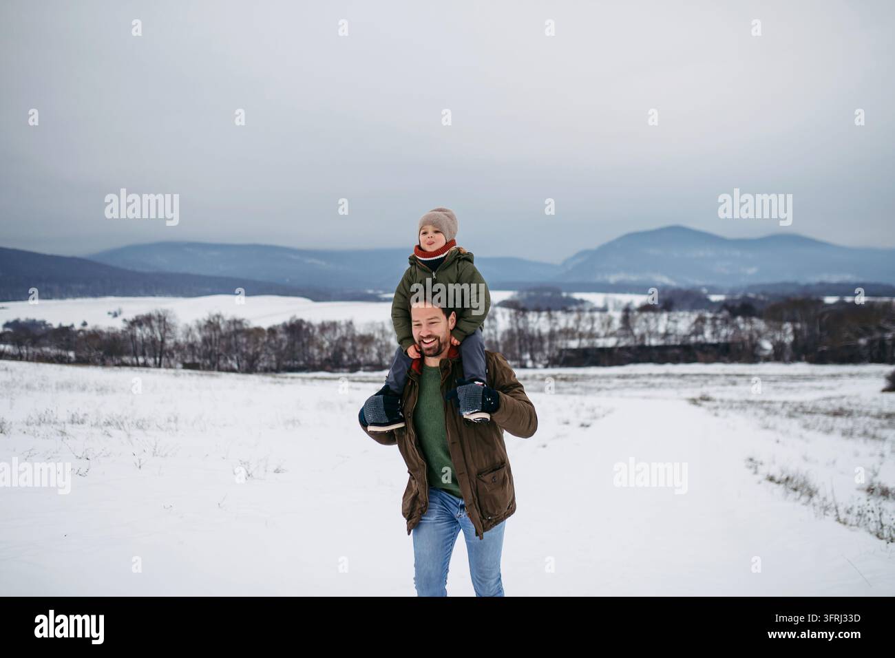 Papà a piedi con il figlio, portandolo sulle spalle. Foto Stock