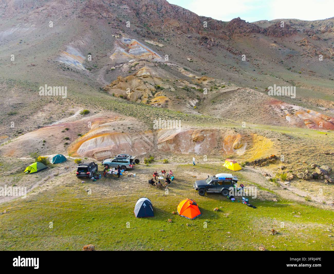 Lago Kel-Suu, regione di Naryn, Kirghizistan - 10 ottobre 2023: Vista elevata di tende colorate e veicoli in un campeggio situato ai piedi di strati Foto Stock