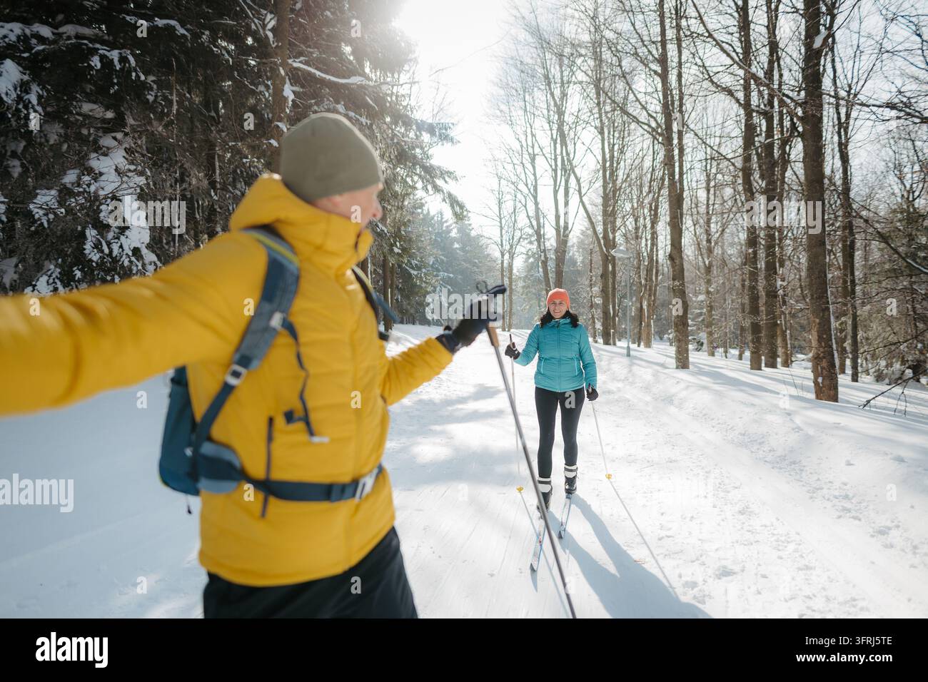 Coppia matura attiva che fa sci di fondo insieme in una foresta innevata. Foto Stock
