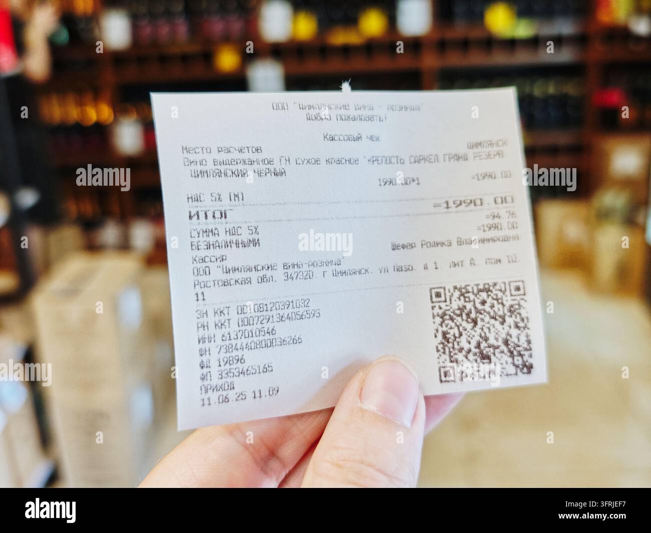 Tsimlyansk, Russia – 11 giugno 2025: Un cliente tiene una ricevuta per articoli di drogheria acquistati alla cassa di un supermercato. La ricevuta mostra la conferma di pagamento Foto Stock
