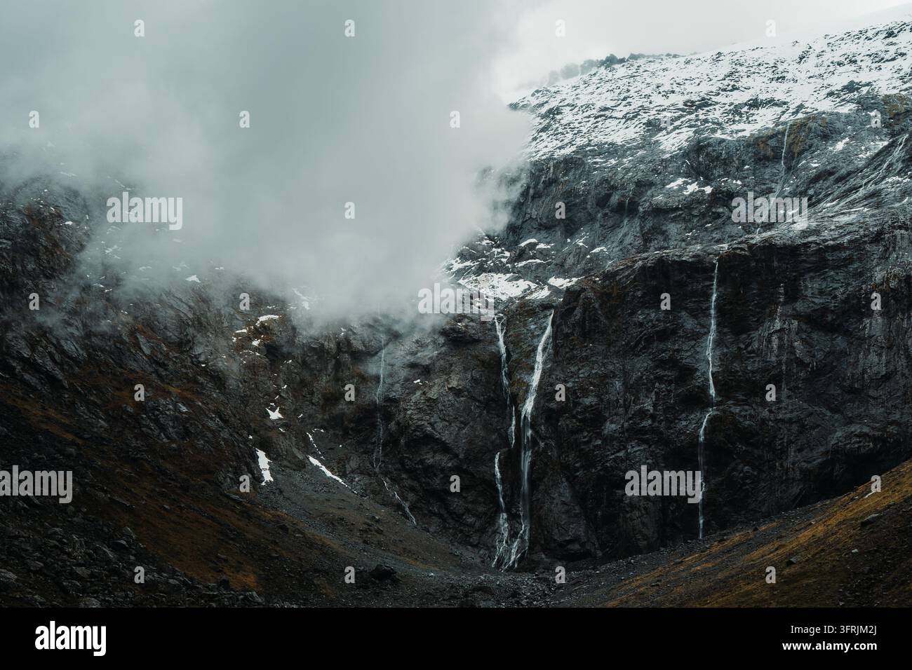 Nebbia e cascate su ripide scogliere boscose, Parco Nazionale di Fiordland, Nuova Zelanda Foto Stock