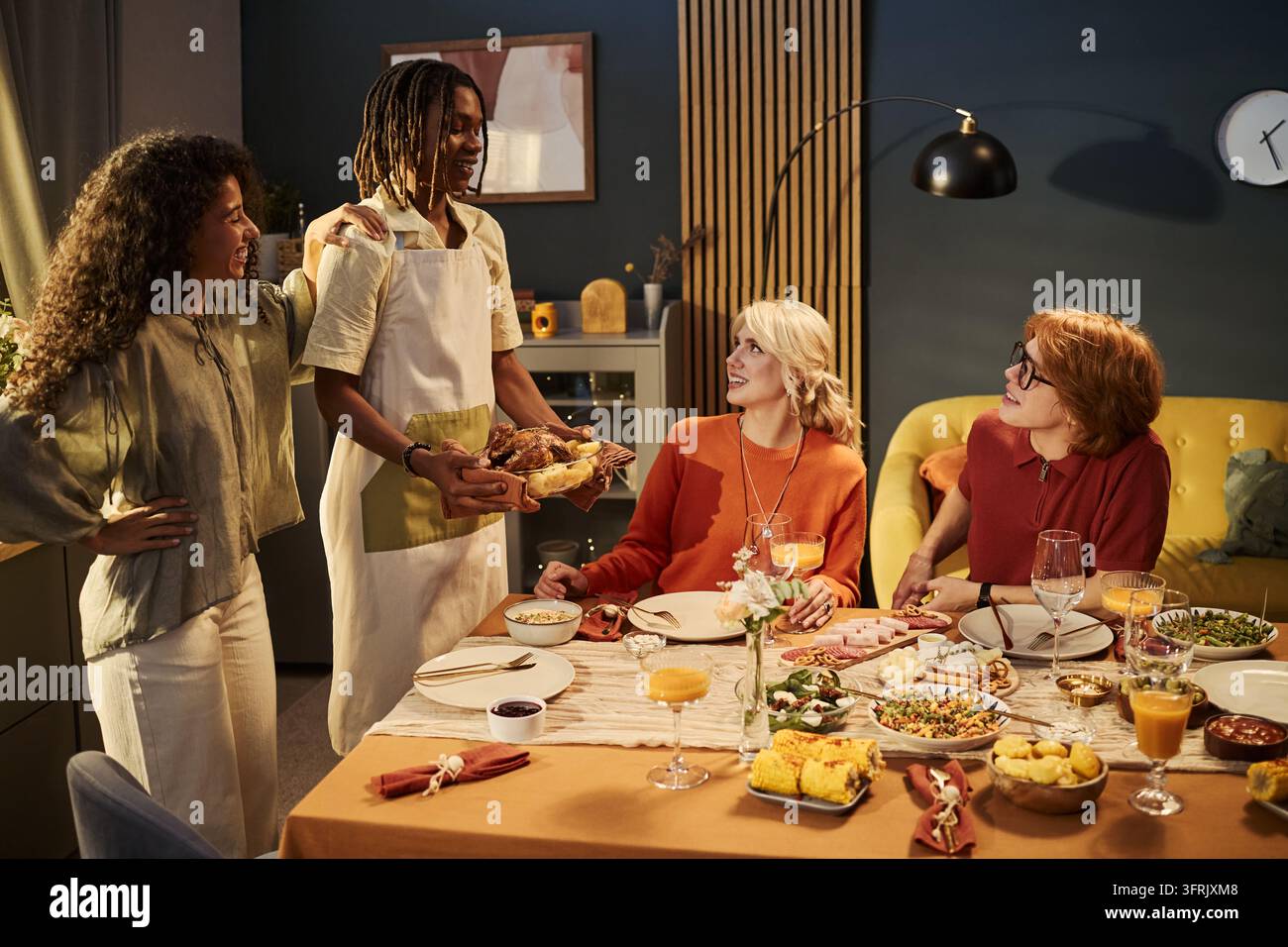 Gruppo multietnico di amici che godono di una cena festosa a casa Foto Stock