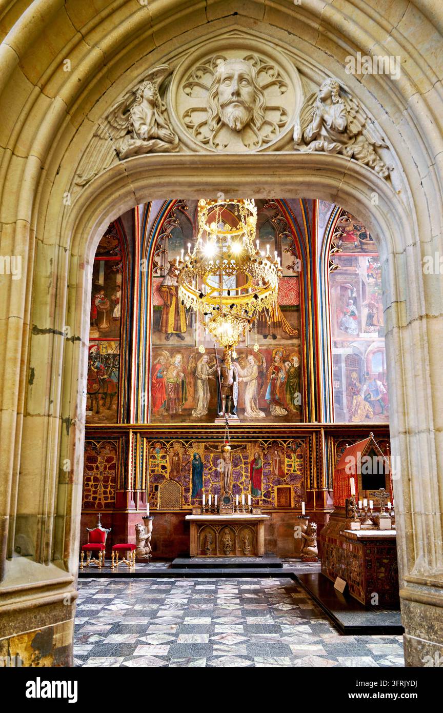 Un portale di pietra gotico incornicia pareti dorate intarsiate con pietre semipreziose, Cappella di San Venceslao, Castello di Praga, Repubblica Ceca Foto Stock