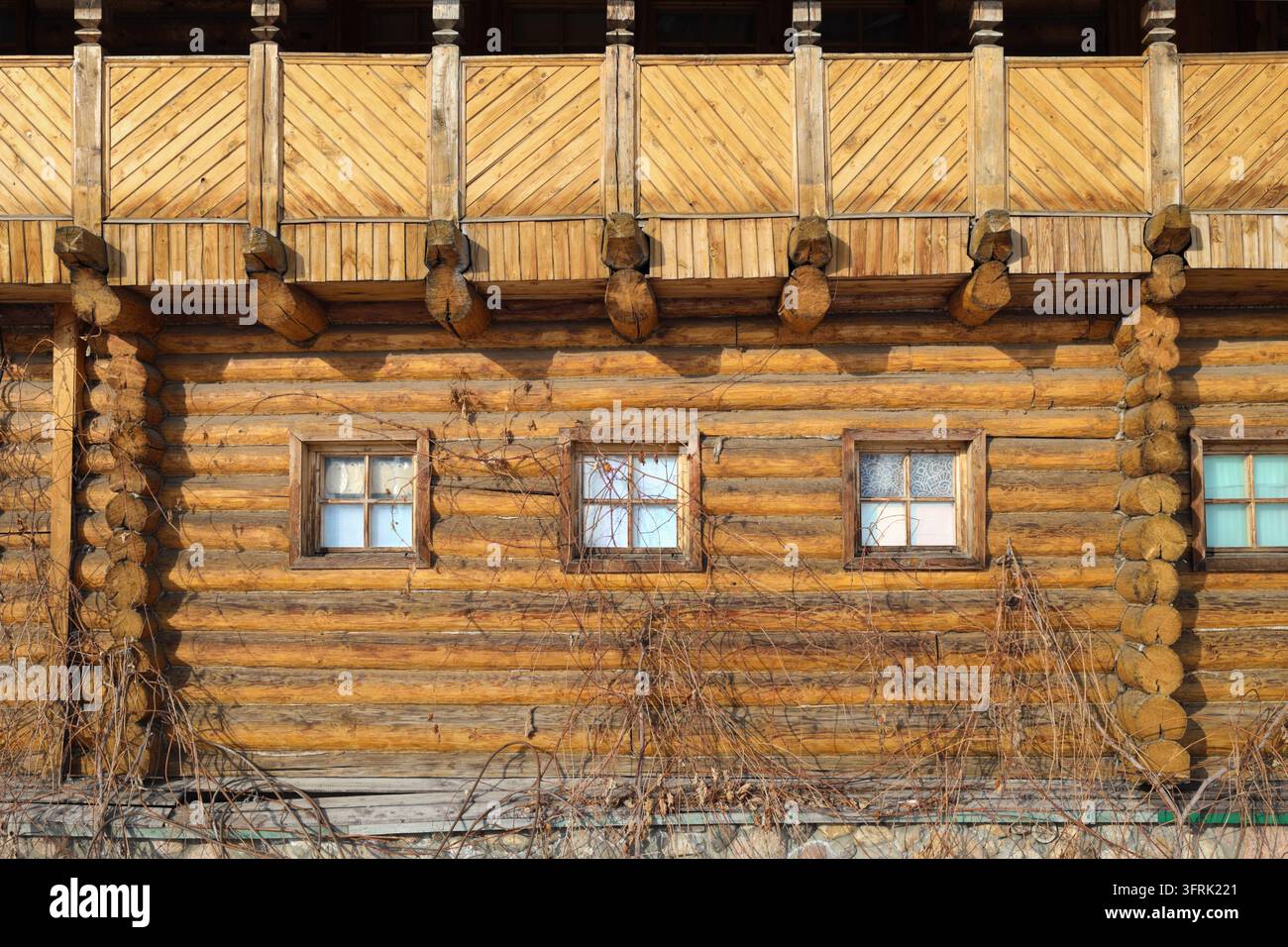 Muro di tronchi nel complesso museale storico del Cremlino a Izmailovo in inverno – Capanna di tronchi con telai di finestre rustici. Le travi di legno ingiallite formano t Foto Stock