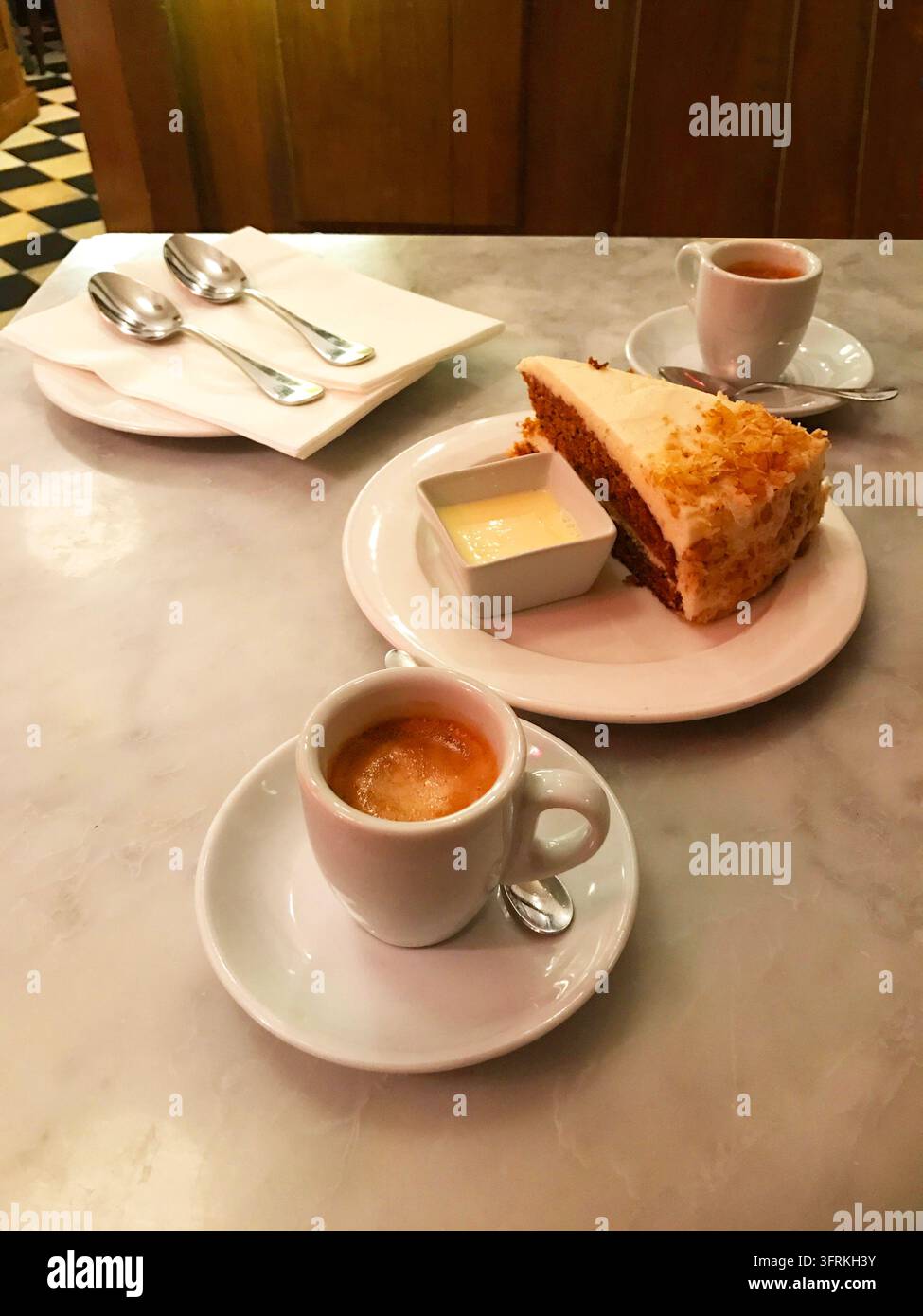 Torta di carote e due tazze di caffè in una caffetteria. Foto Stock