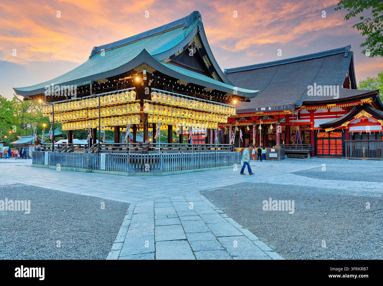 Le lanterne di carta Chochin brillano sul palco Maidono accanto alla sala principale vermiglia del santuario Yasaka a Gion, Kyoto, al crepuscolo in primavera. Foto Stock