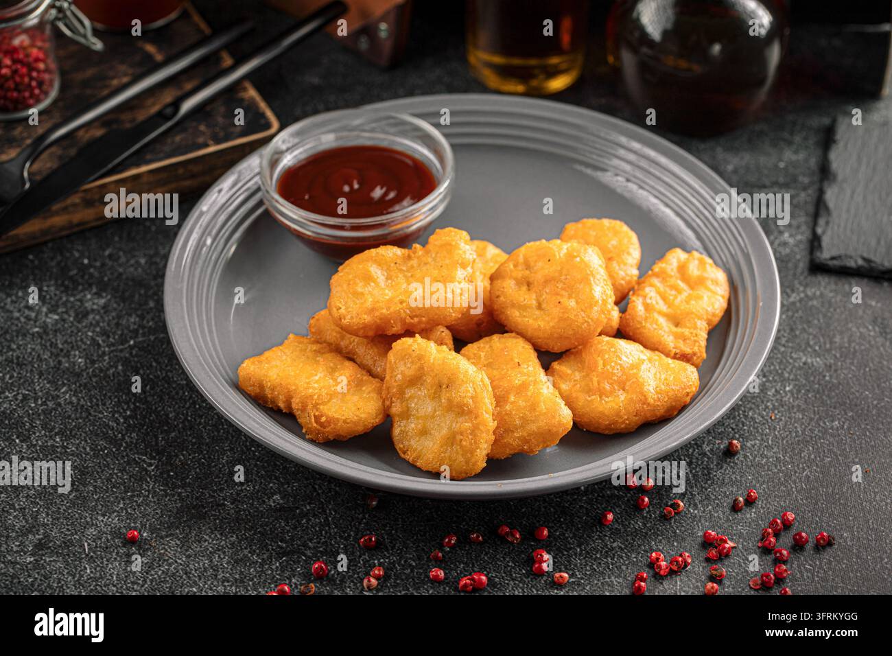 Nuggets di pollo con salsa su piatto grigio Foto Stock