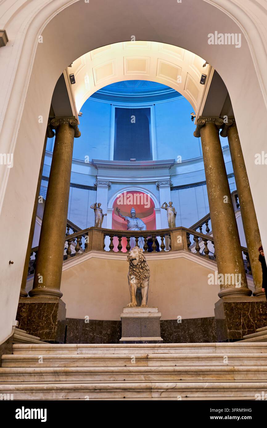 Scultura in marmo di un leone e colonne ioniche alla scalinata monumentale del Museo Archeologico Nazionale di Napoli, Campania, Italia. Foto Stock